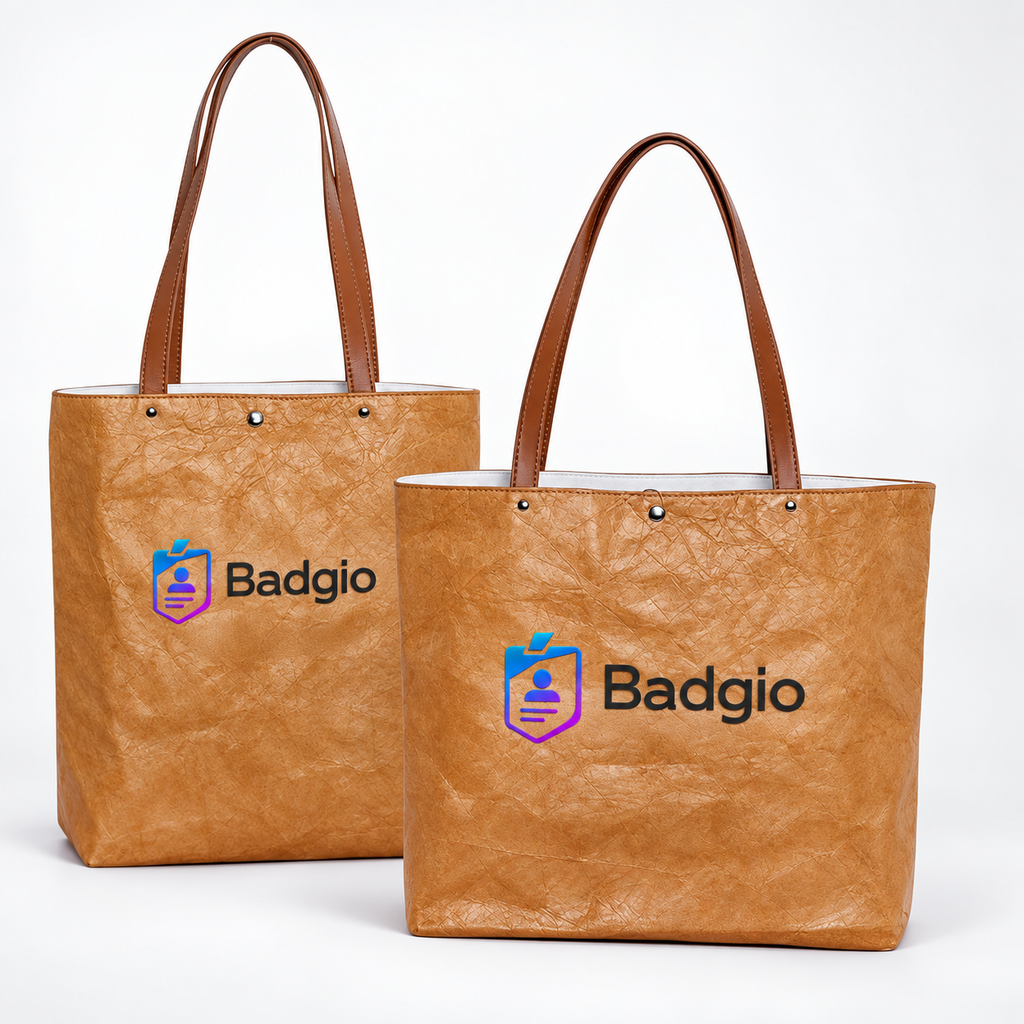 Two tan washable paper tote bags with handles and Badgio logo